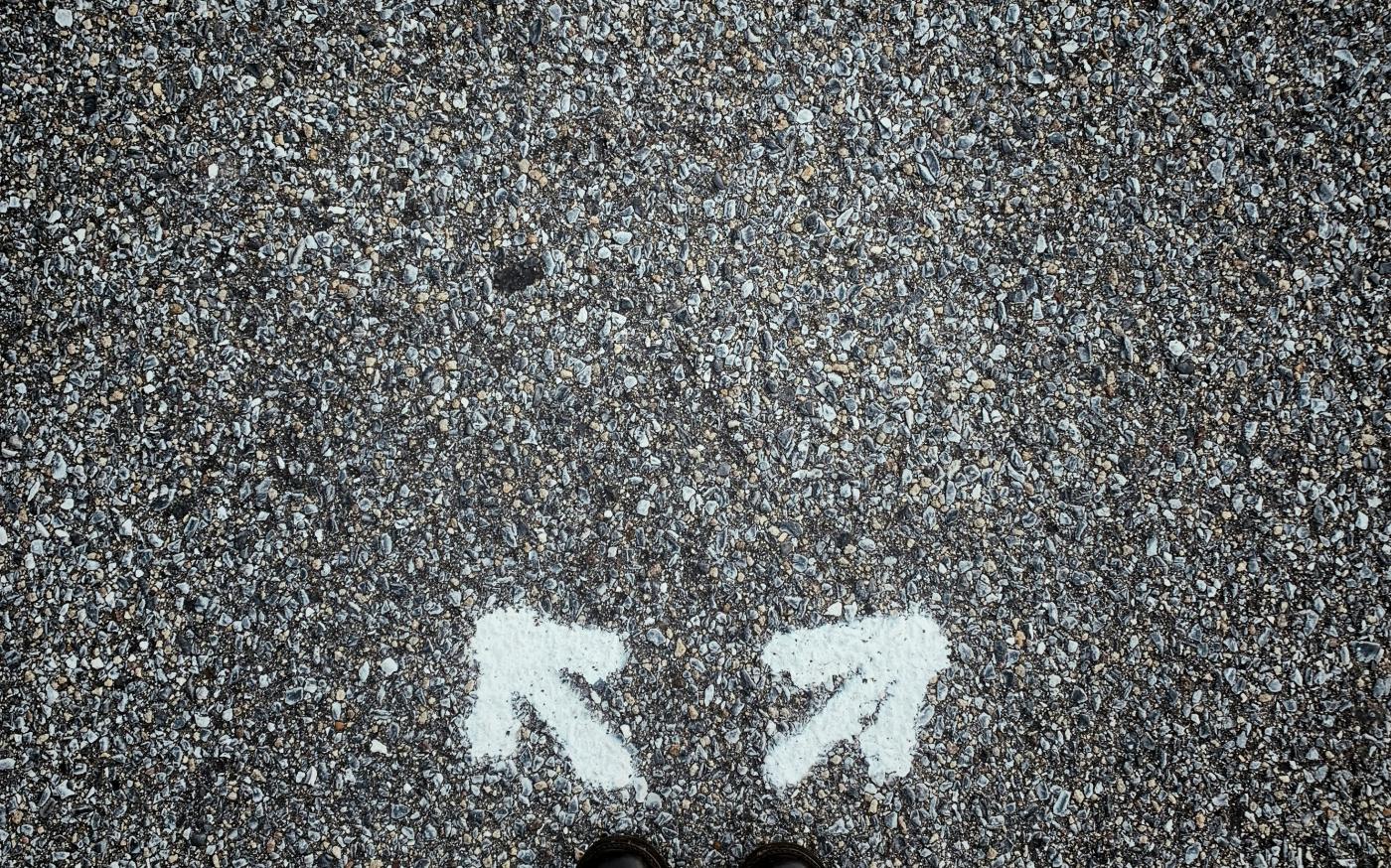 a person standing in the middle of a street by Jon Tyson courtesy of Unsplash.