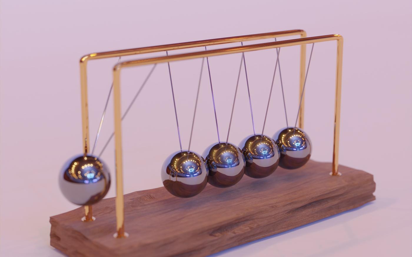 a wooden stand with three metal balls on it by Sunder Muthukumaran courtesy of Unsplash.