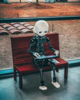 black and white robot toy on red wooden table by Andrea De Santis courtesy of Unsplash.