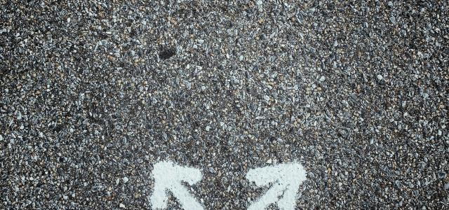 a person standing in the middle of a street by Jon Tyson courtesy of Unsplash.