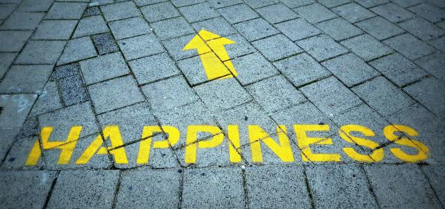 a brick sidewalk with a yellow arrow painted on it by D Jonez courtesy of Unsplash.