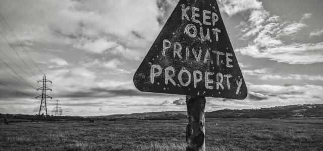 a black and white photo of a sign that says keep out private property by Charlie Hammond courtesy of Unsplash.